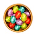 Mixed colored foil wrapped mini chocolate Easter Eggs in wooden bowl