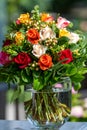 Roses, mixed colorful roses in bouquet. Multicolored roses in red, yellow, orange, rose and bright pink in glass vase.