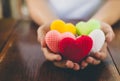 Mixed colors yarn heart on giving hands. Close up of colorful handmade. Healthy heart donation and health care concept. Valentine Royalty Free Stock Photo