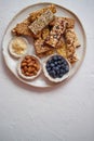 Mixed composition of energy nutrition bar, granola on ceramic plate over white background Royalty Free Stock Photo