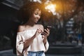 Mixed curly lady with cell phone outdoor