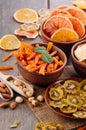 Mixed dried fruit chips, candied pumpkin slices, nuts and seeds on rustic wooden background Royalty Free Stock Photo