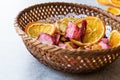 Mixed Dried Fruits Orange, Strawberry, Pineapple, Cherry and Apple Slices with Cinnamon Powder in Wooden Basket Royalty Free Stock Photo