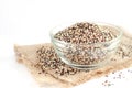Mixed dry organic quinoa seed pile in glass bowl on sack fabric and white background Royalty Free Stock Photo