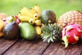 Mixed exotic fruits on wood background. Healthy eating, dieting. Top view with grass copy space Royalty Free Stock Photo