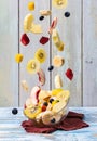 Mixed falling fruits in bowl on wooden background