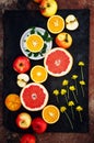 Mixed festive colorful tropical and citrus fruit sliced over black tabletop. Food collage on a rustic surface. Apples, lemons, g Royalty Free Stock Photo