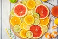 Mixed Fresh slices citrus fruit on a round wooden Board on a light background. Top view Royalty Free Stock Photo