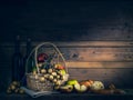 Mixed fruits in basket and wine bottle on wooden table Royalty Free Stock Photo