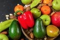Mixed fruits and vegetables - red peppers, avocado, apples, pears, tangerines, pecan nuts, almonds and pumpkin seeds on wooden Royalty Free Stock Photo