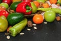 Mixed fruits and vegetables - red peppers, avocado, apples, pears, tangerines, pecan nuts, almonds and pumpkin seeds on wooden Royalty Free Stock Photo