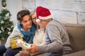Mixed generations people celebrating christmas eve together at home - young teenager grandson or son and old grandfathers or
