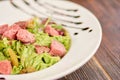 Mixed green salad with beef pieces.