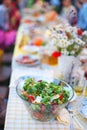 Mixed green salad with carrot and tomatoes on picnic table