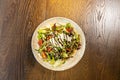 Mixed green salad with shaved parmesan cheese served on wooden table Royalty Free Stock Photo