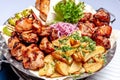 Mixed grill meat fried vegetables and grilled salmon fish fillets decoration in warm dish. Assorted delicious grilled kebab served Royalty Free Stock Photo