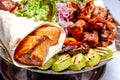 Mixed grill meat fried vegetables and grilled salmon fish fillets decoration in warm dish. Assorted delicious grilled kebab served Royalty Free Stock Photo