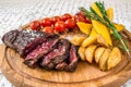 Mixed grilled meat, potatoes, tomatoes with herbs Royalty Free Stock Photo