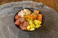 Mixed Hawaiian poke bowl with salmon, fish roe, red tuna with mango and surimi and lots of chopped chives