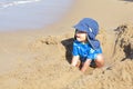 Mixed little toddler boy playing in sand on beach by sea Royalty Free Stock Photo