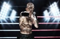 Mixed martial artist posing in the ring against spotlights. Concept of mma, ufc, thai boxing, classic boxing