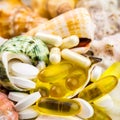 Mixed natural food supplement pills on the beautiful seashells background