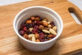 Mixed nuts with cranberries and raisins in white bowl on cutting board Royalty Free Stock Photo