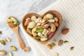 Mixed nuts in heart wood bowl and spoon on linen tablecloth Royalty Free Stock Photo