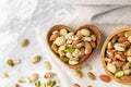Mixed nuts in heart wooden bowl on linen cloth on marble background Royalty Free Stock Photo