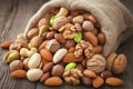 Mixed nuts scattered on gray wooden table from linen bag Royalty Free Stock Photo