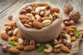 Mixed nuts scattered on gray wooden table from linen bag