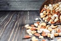 Mixed nuts spilling out of bowl on wooden table. Macro still-life with shallow dof Royalty Free Stock Photo