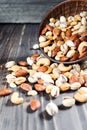 Mixed nuts spilling out of bowl on wooden table. Macro still-life with shallow dof Royalty Free Stock Photo