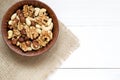 Mixed nuts in wooden bowl on the white wooden table. Background, copy space, top view, close up Royalty Free Stock Photo