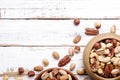 Trail mix with different kinds of nuts in brown wood bowl on scratched white wooden table background, soft daylight. Copy space. Royalty Free Stock Photo