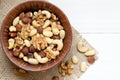 Mixed nuts in wooden bowl on the white wooden table. Background, copy space, top view, close up Royalty Free Stock Photo