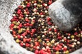 Mixed peppercorn seeds in granite pestle or mortar
