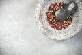 Mixed peppercorn seeds in granite pestle or mortar