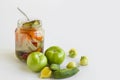 Mixed pickle jar with unripe,pickled vegetables on white background with copy space.