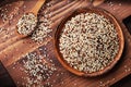 Mixed quinoa in bowl on wooden kitchen board top view.