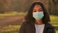 Mixed race African American girl biracial teenager teen young woman outside wearing a face mask during COVID-19 Coronavirus pan