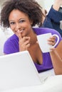 Mixed Race African American Girl Using Laptop Computer Drinking Coffee or tea Royalty Free Stock Photo