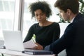 Multiracial colleagues analyzing financial report during meeting in office