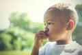 Mixed race between Asian and African American kid thinking and being curious outdoor.