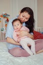 Mixed race Asian mother holding touching embracing her cute adorable newborn infant baby Royalty Free Stock Photo