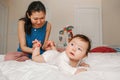 Mixed race Asian mother with newborn baby doing heels foot massage and physical exercises. Royalty Free Stock Photo