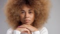 Mixed race black woman with big afro hair in studio put a cream smudge