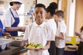 Mixed race boy holding a plate of food in a school cafeteria Royalty Free Stock Photo