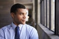 Mixed race businessman looking out of window, portrait Royalty Free Stock Photo