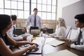 Mixed race businessman stands addressing team in a meeting Royalty Free Stock Photo